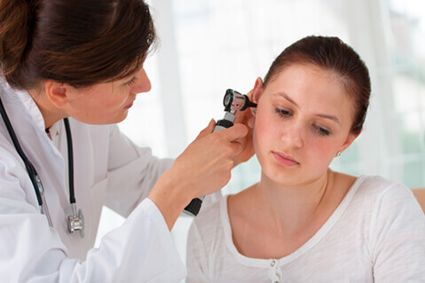 Young woman having ear examined