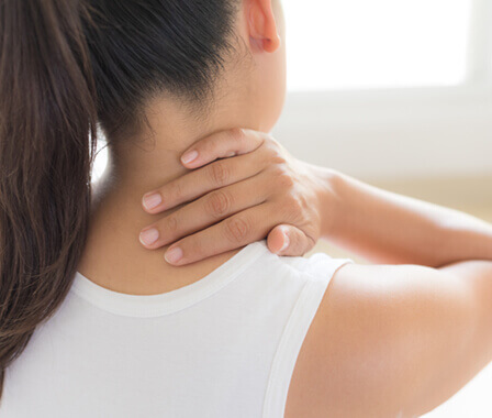 Athletic woman rubbing back of neck